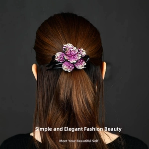 Detail of pink and white crystal flower hair claw clip worn on long brown hair
