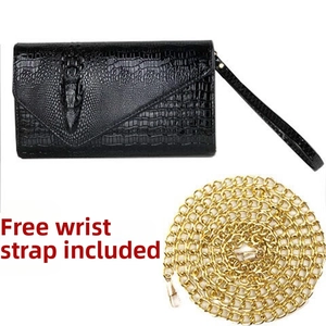 Detail of black crocodile texture envelope clutch with gold chain and wristlet strap