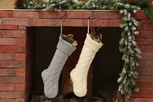 Close-up of cable knit texture on grey and white Christmas stockings by fireplace