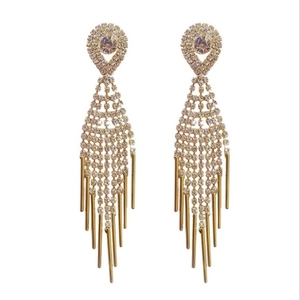 Close-up of elegant gold tassel earrings featuring detailed white rhinestone inlay