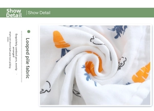 Detail of soft 6-layer cotton gauze fabric with cute carrot and bunny print for babies