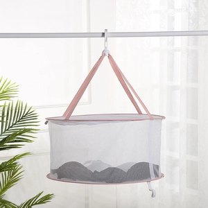 Mesh laundry drying basket with pink trim and white hook hanging on a drying rack
