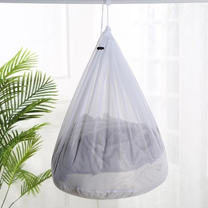 Close-up of durable white mesh laundry bag with drawstring shown in a bright home setting