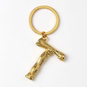 Golden tree branch texture letter keychain pendant on white background with metal ring