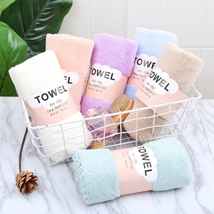 Detail view of colorful soft coral velvet towels neatly rolled in a stylish metal basket