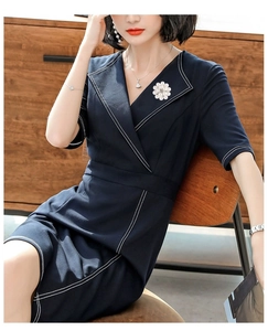 Close-up of pearl flower brooch with tassel on a navy blue v-neck dress