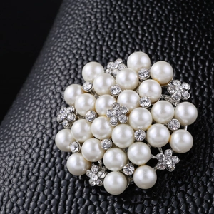 Detailed macro view of pearl and rhinestone floral brooch with silver alloy base