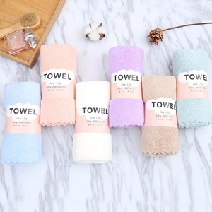 Detailed close-up of six soft coral velvet towels in assorted colors with paper wrapping