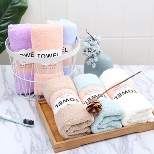 Set of six colorful coral fleece towels 35x75cm rolled in a decorative iron basket