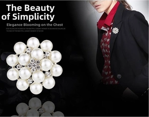 Detail of floral brooch with white pearls, central rhinestones, and silver base on attire