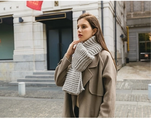 Outdoor street style view of woman wearing a thick gray chunky knit winter scarf