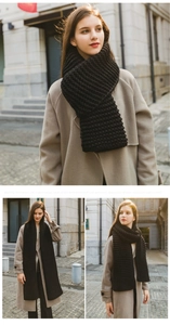 Close-up of thick black chunky knit scarf showing detailed texture and warm wool material