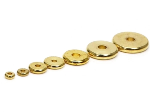 Flat solid brass spacer beads for DIY jewelry arranged by size on white background