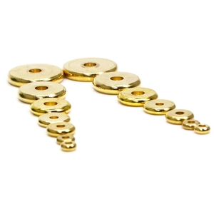 Flat solid brass spacer beads in various sizes with polished golden finish on white background