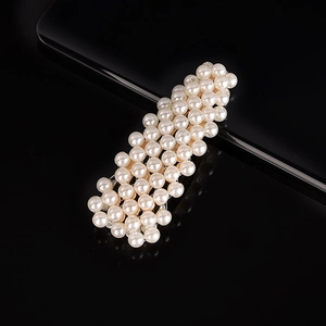 Detailed view of handcrafted white pearl hair clip with elegant glossy finish