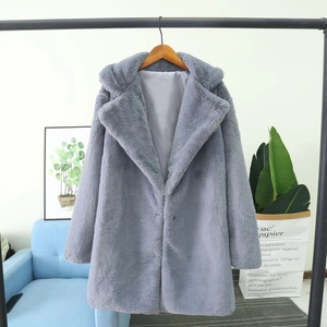Détail d'un manteau en fausse fourrure bleu-gris avec revers sur un cintre noir