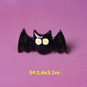 Detail of a black resin bat charm with white eyes for DIY Halloween accessories