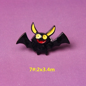 Macro detail of cartoon bat resin accessory with black body and large yellow eyes