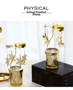 Detail shot of a golden rotating candle holder with snowflake charms and glass base