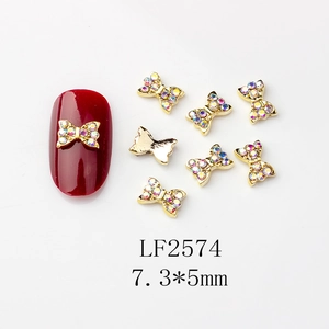 Détail macro de nœuds dorés pour nail art avec strass, dimensions de 7,3x5mm environ