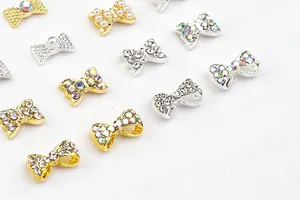 Détail de bijoux d'ongles en alliage en forme de nœud avec strass et perles blanches