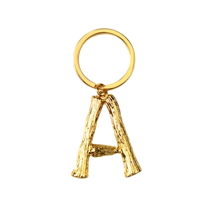 Vintage golden metal letter A keychain with unique branch texture on white background