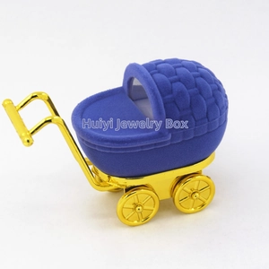 Detailed view of royal blue flocked baby stroller jewelry box with gold metal wheels