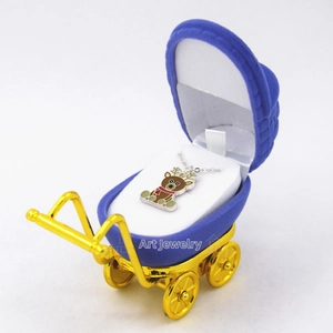 Detailed view of a reindeer necklace inside a blue velvet stroller shaped jewelry box