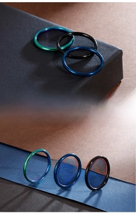 Detailed view of minimalist stainless steel rings in blue, black, and rainbow colors
