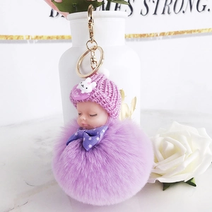 Detail of purple plush doll keychain with sleeping baby head and For You heart charm