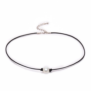 Detailed shot of a black leather necklace featuring a single white pearl and silver clasp