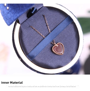 Rose gold heart pendant necklace with red gemstone in a blue velvet gift box
