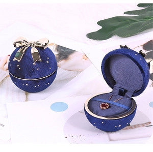 Blue spherical velvet jewelry box with golden bow and starry pattern for necklaces