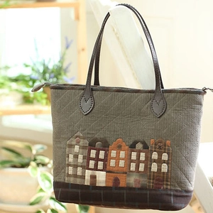 Olive green quilted tote bag with house appliqué and durable brown leather handles