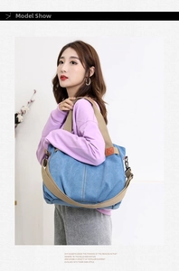 Close-up of blue canvas tote bag showing stitching details and metal strap hooks