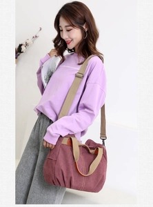 Model wearing large burgundy canvas crossbody bag showing size and capacity for daily use