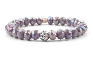 Macro view of faceted natural amethyst beads and multi-colored rhinestone charm on bracelet