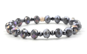 Close-up of faceted natural amethyst and black beads with a gold hexagonal accent bead
