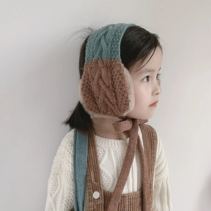 Close-up of kids knitted earmuffs with brown and teal color block and plush lining