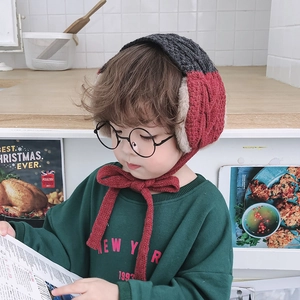 Close-up of dual-color knit child hat with red bow tie and soft beige plush lining