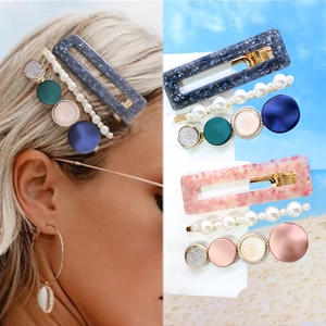Detail of handmade woven hair clips set including pearl bow and floral acetate patterns