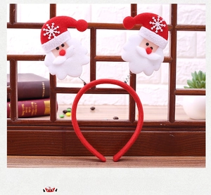Detail of Christmas headband featuring plush Santa Claus on springs with white snowflakes