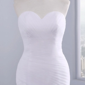 Detail of sweetheart neckline and pleated texture on a white formal cocktail dress