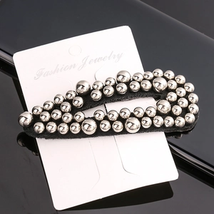 Detail of fashion BB hair clip featuring silver beads on black fabric over a jewelry card