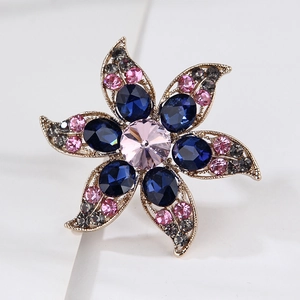 Macro shot of luxury flower brooch with navy blue crystals and pink rhinestones detail
