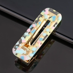 Macro shot of rectangular acetate hair clip with colorful mosaic resin and gold metal base