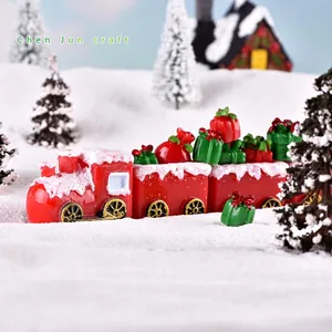 Christmas miniature red steam train figurines with snow effect on trees and landscape