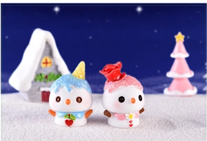 Close-up of cute resin snowman figurines with ice cream cone and floral hats