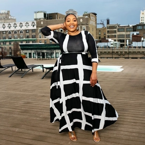 Plus size black and white plaid maxi dress with half sleeves in an outdoor urban setting