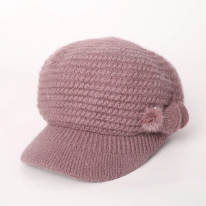 Detail der lila Strickmütze mit Plüschblume und dicker Wintertextur für Damen